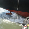 船上動力啟動擺舵啟航，拖船在船艉幫助推拉正確航向。