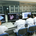 中國自製超級計算機「天河一號」（背景）和正在進行測試的科學家們