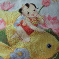 很富中國色彩的十字繡，很有賀節氣氛，紅孩兒坐在用多種金黃線繡成的娌魚，在荷塘裡游，玩得不亦樂呼！