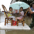 13A resident pulls a makeshift raft to transport two girls across a flooded street after Typhoon Morakot struck Cangnan county, in China's Zhejiang province, August 10, 2009. (REUTERS/Lang Lang)