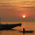 A fisherman paddles his canoe past a fishing vessel during sunrise as the weather clears after continued rain brought by Typhoon Morakot stopped in the central Philippine island of Cebu August 9, 2009. (REUTERS/Victor Kintanar)