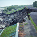 Water flows past a severely eroded embankment near a damaged bridge that previously linked Pingtung and Kaohsiung, in southern Taiwan on August 9, 2009. (SAM YEH/AFP/Getty Images)