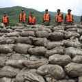 Paramilitary policemen stand on a pile of sandbags at a section of Yangjia Stream of Xiapu county in Ningde, Fujian province August 10, 2009. (REUTERS/Stringer)