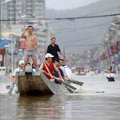 People row a dragon boat to commute through a flooded area in Cangnan county, in east China's Zhejiang province, Monday Aug. 10, 2009. (AP Photo)