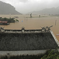 Paramilitary policemen pilot a motorboat through a flooded village in Cangnan county, eastern China Sunday Aug. 9, 2009. (AP Photo)