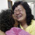 Two women hold each other in a local emergency room after being rescued by helicopter from a village covered in a landslide from Typhoon Morakot in Kaohsiung county, southern Taiwan, Monday. Aug. 10, 2009. (AP Photo)