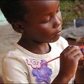 David Steggall snapped this Kenyan girl, wearing a top with a purple flower on it, without her even noticing - she was too busy painting.