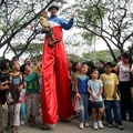 菲律賓一位踩高蹺表演者1日在奎松市的公園裡和孩子同樂，開心過元旦。歐新社 99年1月1日
