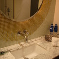 浴室以金、銀、白為主色，牆面以玻璃馬賽克鑲嵌，空間低調奢華。