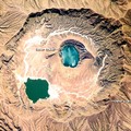 這個火山在地質學上是個年輕的火山構造,位於蘇丹西部.內部火山口湖顯現的斑瀾顏色是太空人拍照時的sunglint造成(光線反射於特定角度); 它,很恰巧地顯現出一個以左手遮住一小部份臉的女人圖像...奇妙又美麗