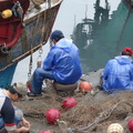 宜蘭縣的大溪漁港，那天下雨風浪也大，漁夫趕著補破網，等待出帆！