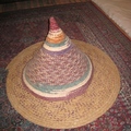「阿那布達房子」的客廳，地上舖著美麗的地毯，上面放著一頂像帽子的器物