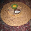 用草編成像帽子的器物，原來是防沙塵的罩子，裡面放著茶具啦！
