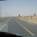 穿越沙漠的公路，筆直地通向遠方，兩旁的景色很單調，用柵欄隔開，是防駱駝進入