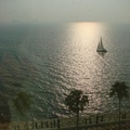 由Burj Al Arab帆船飯店的窗口看出去，夕陽下，波光閃閃的海面，有一艘帆船行過，非常美！