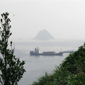 基隆嶼在右前方隱隱出現，小貨櫃輪正進入港灣。