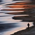 A man runs along Sydney's Long Reef Beach at sunset on the shortest day of the year, known as the winter solstice, June 21, 2005.  REUTERS/David Gray