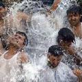 Pakistani men take bath to cool down from a severe heat wave in the capital Islamabad June 21, 2005. REUTERS/Mian Khursheed