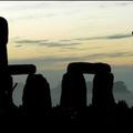 A man climbs onto the stones as the sun rises on the Summer Solstice at Stonehenge in Wiltshire, England.(AFP/John D. McHugh)