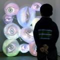 A visitor examines a DVD production of blinking eyes called 'Viz' by New York based artist Tony Oursler at the 36th Art in Basel, Switzerland, June 14, 2005.  REUTERS/Siggi Bucher