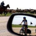 Two sisters from New Zealand who are biking across Canada watch as cowboys trail 200 bronc horses along Highway 56 near Hussar, Canada, June 30, 2005. REUTERS/Patrick Price