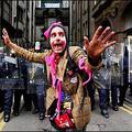 G8 demo : Police officers in riot kit block a street as a protester (C) who is participating in the 'carnival for full enjoyment' rally stands in front of them in Edinburgh, Scotland. (AFP/Nicolas Asfouri)