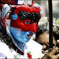 Can you hear me now..? : A Salvadoran wearing a mask looks at his mobile phone while taking part in a festival to celebrate San Salvador's patron saint 'the Divine World's Savior' day. (AFP/Yuri Cortez)