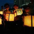 Children deliver lanterns to the Urakami river to pay tribute to the victims of the atomic bombing in Nagasaki, southwestern Japan, Tuesday, Aug. 9, 2005.  (AP Photo/Junji Kurokawa)