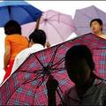 Rainy Beijing : People hold umbrellas as heavy rains falls as Beijing receives the tail end of Tyhoon Matsa. (AFP/Peter Parks)