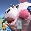 Mackenna Johnson, 2, gets a lift from her mother, Joyce, as she puts some money into the world's largest piggy bank during a visit to the California State Fair, Friday, Sept. 2, 2005.  (AP Photo/Rich Pedroncelli)