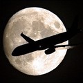 A plane is seen flying past the moon over the western town of Frankfurt/Main. (AFP/DDP/Torsten Silz)