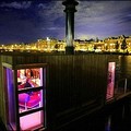 A mother holding her newborn baby watches television inside her houseboat along the inner waters of the Amsterdam canal, as the Netherland's capital can be seen in the background. (AFP/Mauricio Lima)