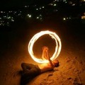 A juggler spins firesticks as the moon rises over Clifton beach in Cape Town, South Africa, November 14,2005.