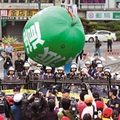 圖為參與遊行民眾把「反派遣」的大汽球推向行政院的方向，希望政府全面禁止勞動派遣。（姚志平攝）2010.5.2中時