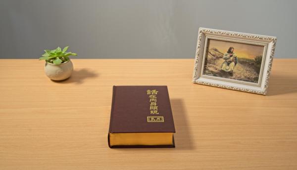 書桌上放著一本話在肉身顯現和一個主耶穌的畫冊