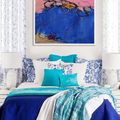 White bedroom features a large abstract over the bed, tied in with bright blue and turquoise linens. Stunning color. 