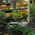 Patio next to elevated living areas with glass walls overlooking the lush vegetation surrounding a pond, Dunbar–Southlands, Vancouver, Canada