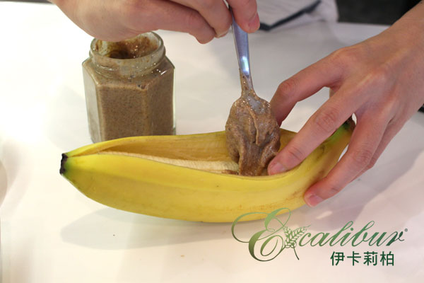 先把香蕉從中間切開，將杏仁醬盡量塗抹在整根果肉上與兩側。