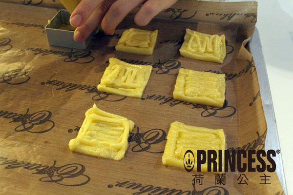 做好的麵糰放入擠花袋中，在烤焙紙上擠出大小一致的方形