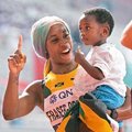 世界田徑賽女子一百公尺摘金的牙買加弗雷澤─普萊斯（左），賽後教兒子比第一的手勢。 （新華社）